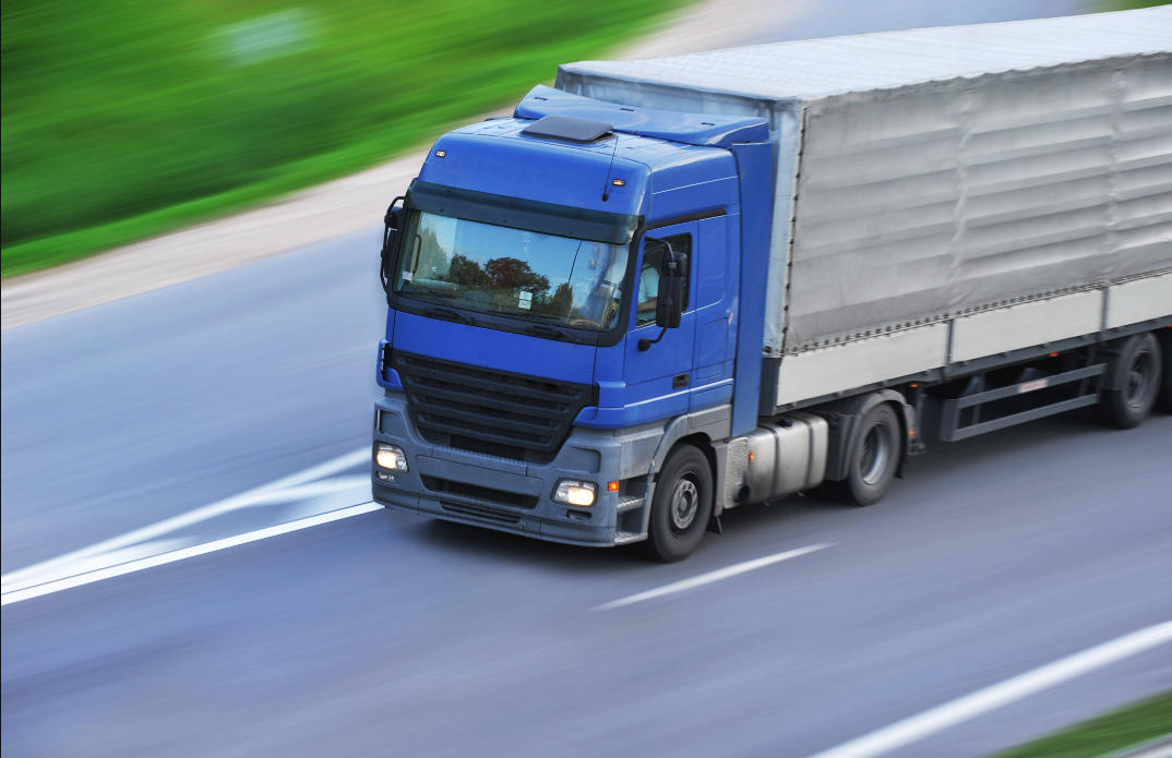 回程车整车物流公司的大型货运卡车正在运输货物，回程车整车物流服务